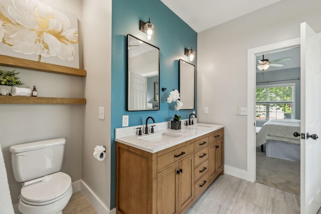 bathroom with a sink, ceiling fan, toilet, and connected bathroom