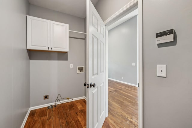 laundry area featuring baseboards, hookup for a washing machine, wood finished floors, hookup for an electric dryer, and cabinet space