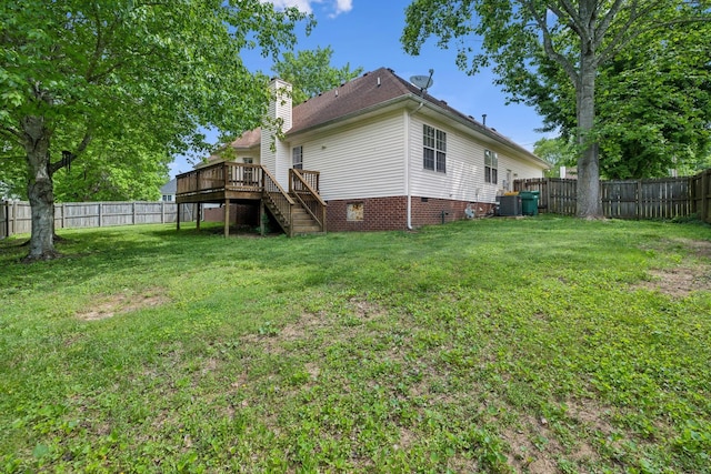 rear view of property with a deck, a yard, stairway, a fenced backyard, and a chimney