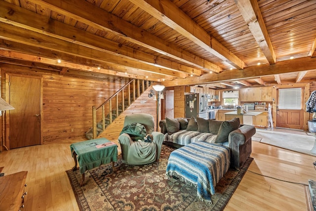 living room with wood walls, light wood-type flooring, and beam ceiling