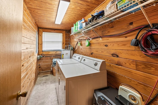 laundry room with separate washer and dryer, wooden ceiling, wooden walls, and gas water heater