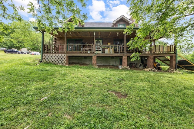 rear view of property featuring a wooden deck and a lawn