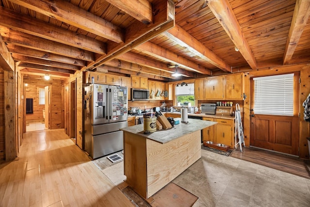 kitchen with wooden walls, stainless steel appliances, beam ceiling, and wood ceiling