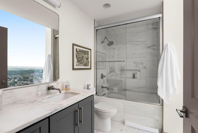 bathroom with toilet, vanity, and tiled shower / bath
