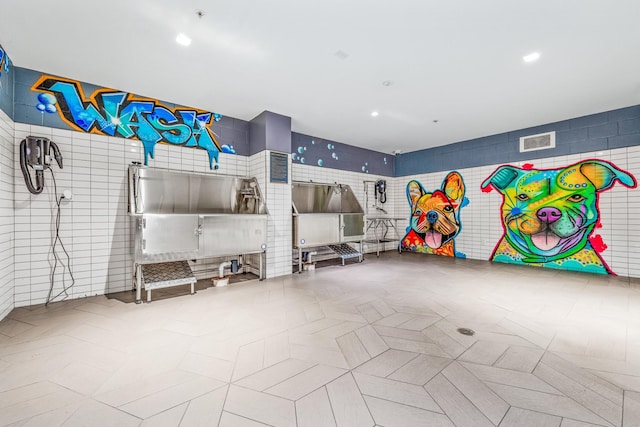recreation room with tile walls, recessed lighting, and visible vents