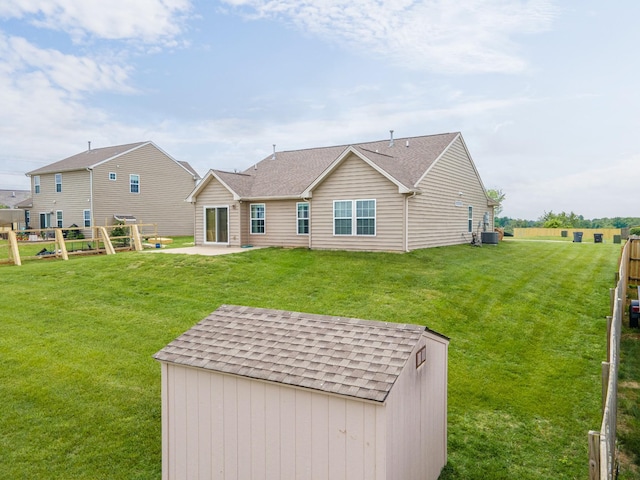 back of property with a lawn, a patio area, cooling unit, and a shingled roof