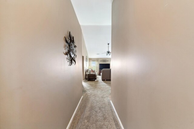 hall featuring carpet flooring and baseboards