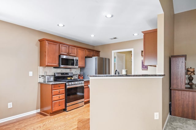 kitchen featuring backsplash, recessed lighting, light wood-type flooring, and appliances with stainless steel finishes