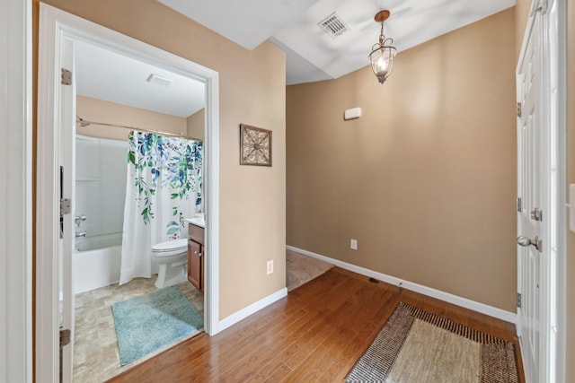 entryway featuring visible vents, wood finished floors, and baseboards