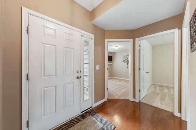 entryway featuring baseboards and dark wood-style floors