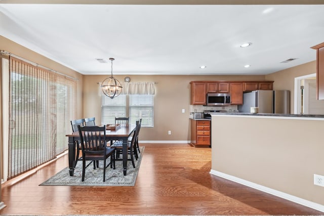 dining space featuring light wood-type flooring, visible vents, recessed lighting, an inviting chandelier, and baseboards