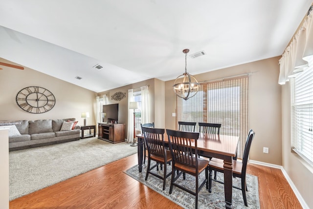 dining room featuring a chandelier, light wood finished floors, and visible vents