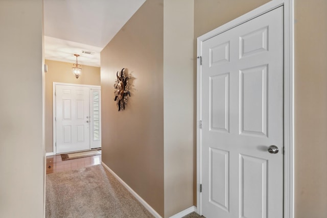 corridor featuring carpet, baseboards, and visible vents