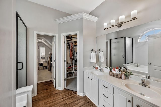 full bathroom featuring a garden tub, wood finished floors, a shower stall, and a sink