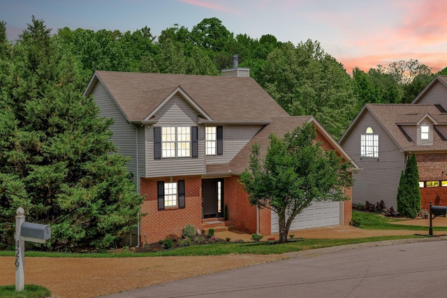 view of front of home with concrete driveway, a chimney, brick siding, and a garage