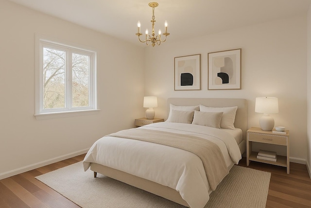 bedroom featuring a chandelier, baseboards, and wood finished floors