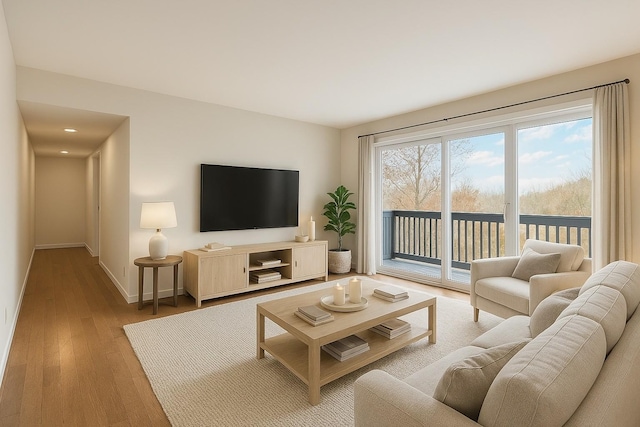 living room featuring baseboards and hardwood / wood-style flooring