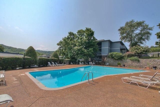 pool with a patio and fence