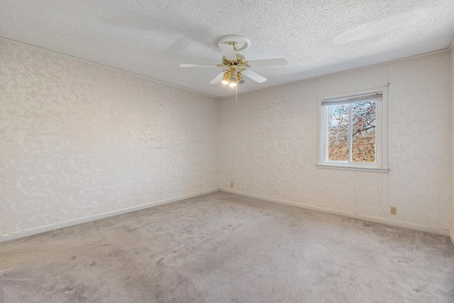 spare room with carpet flooring, a textured ceiling, baseboards, and ceiling fan