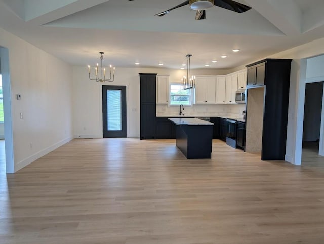 kitchen with stainless steel microwave, recessed lighting, open floor plan, black range with electric cooktop, and a kitchen island
