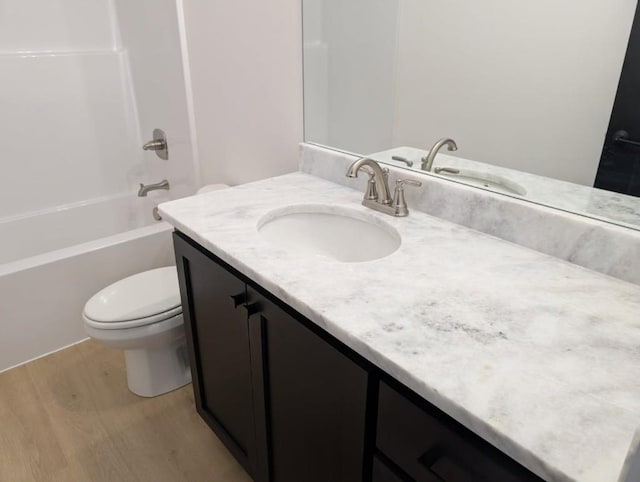full bath featuring toilet, vanity, shower / bathing tub combination, and wood finished floors