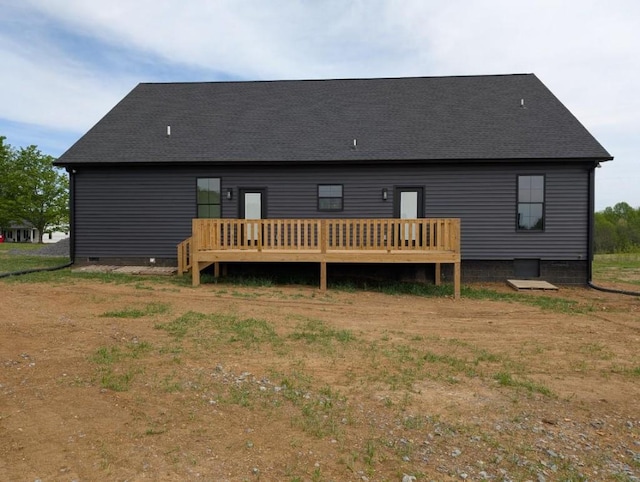 back of house with roof with shingles, a deck, and crawl space