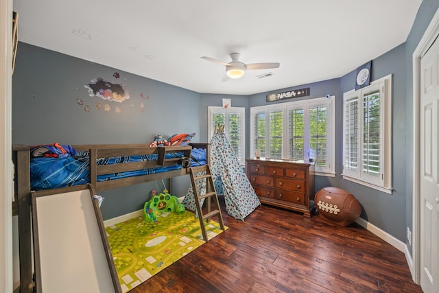 bedroom with a ceiling fan, visible vents, wood finished floors, and baseboards