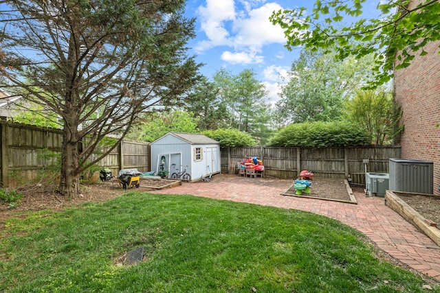 view of yard featuring a fenced backyard, a storage shed, a patio, and an outbuilding