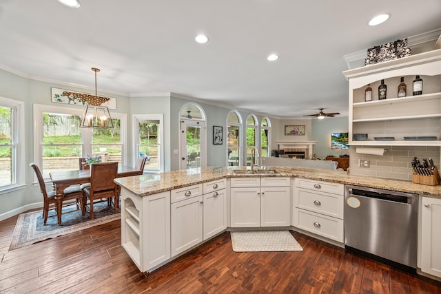 kitchen featuring a sink, a warm lit fireplace, open shelves, crown molding, and stainless steel dishwasher