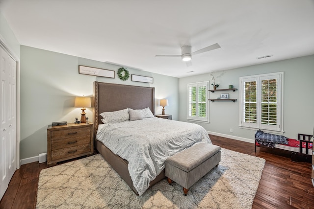 bedroom featuring a closet, wood finished floors, visible vents, ceiling fan, and baseboards