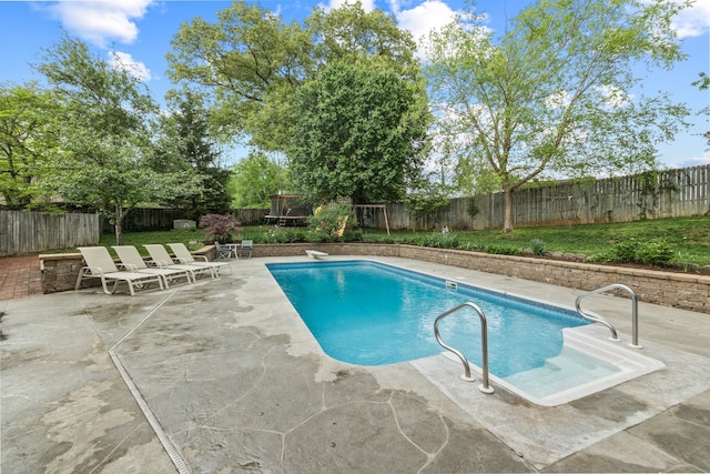 view of pool featuring a fenced backyard, a trampoline, a patio, and a fenced in pool