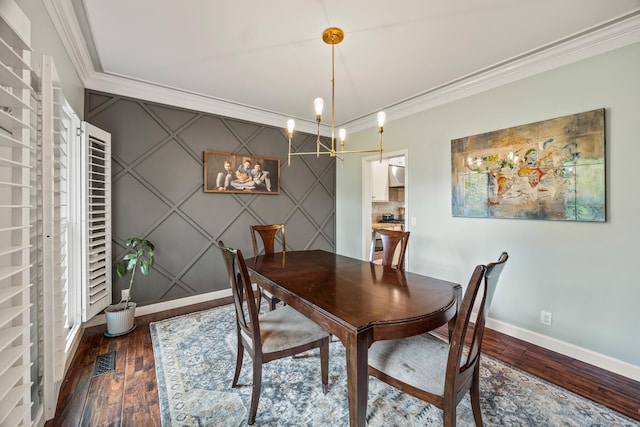 dining space featuring ornamental molding, visible vents, an accent wall, wood-type flooring, and baseboards