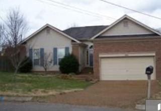 ranch-style home with concrete driveway and a garage