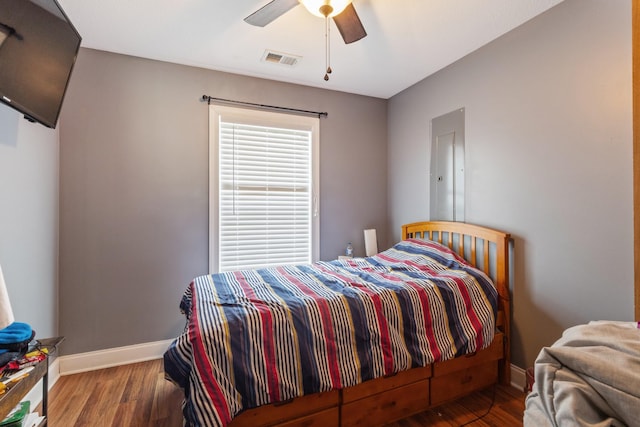 bedroom featuring ceiling fan, baseboards, visible vents, and wood finished floors