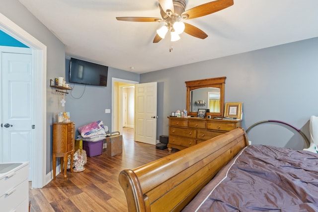 bedroom with baseboards, wood finished floors, and a ceiling fan
