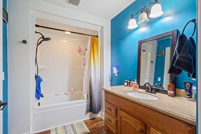 bathroom featuring shower / tub combo, visible vents, wood finished floors, and vanity