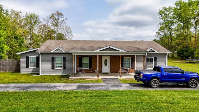ranch-style home with a front yard, a porch, and fence