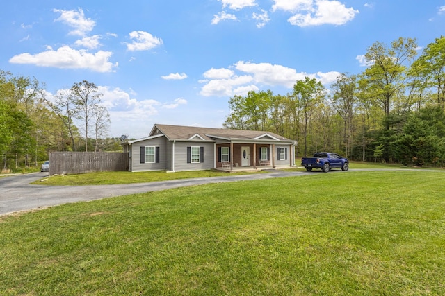 ranch-style house featuring a front yard, a porch, aphalt driveway, and fence