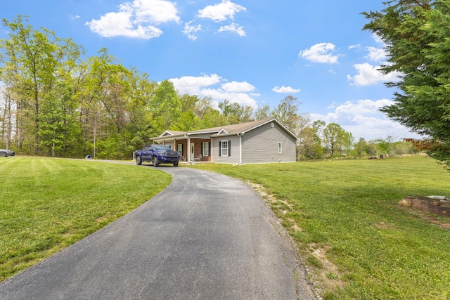 ranch-style home featuring aphalt driveway and a front yard