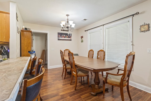dining area featuring baseboards, an inviting chandelier, visible vents, and dark wood-style floors