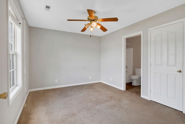 unfurnished bedroom featuring carpet flooring, baseboards, visible vents, and multiple windows