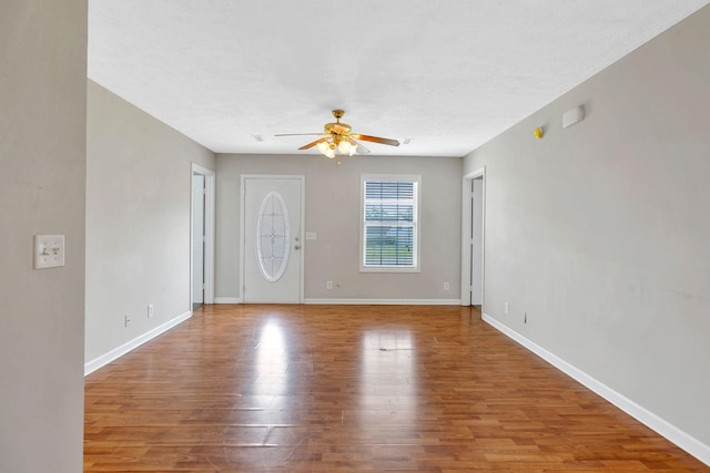 entrance foyer featuring baseboards, ceiling fan, and wood finished floors