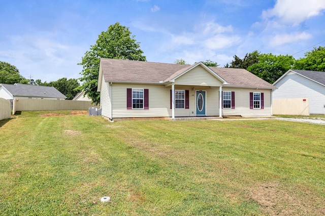 view of front of house with a shingled roof, a porch, fence, and a front yard