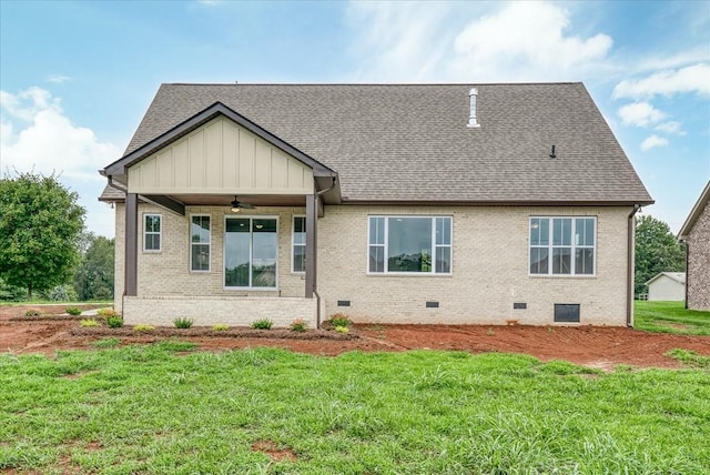 back of property with a lawn, roof with shingles, ceiling fan, and crawl space