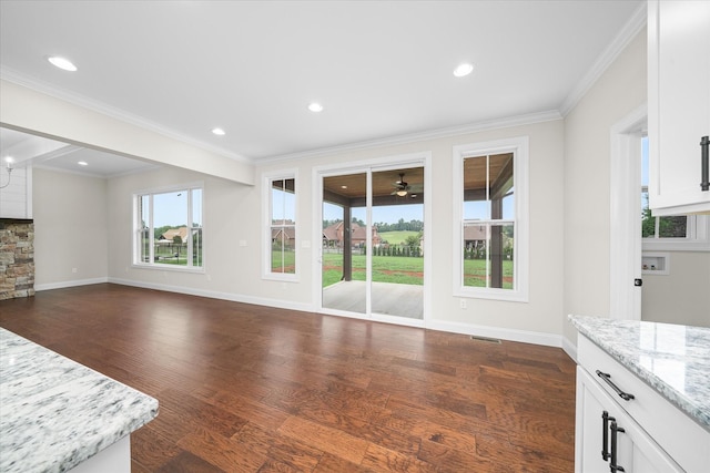 unfurnished living room with baseboards, ornamental molding, a ceiling fan, and dark wood-type flooring
