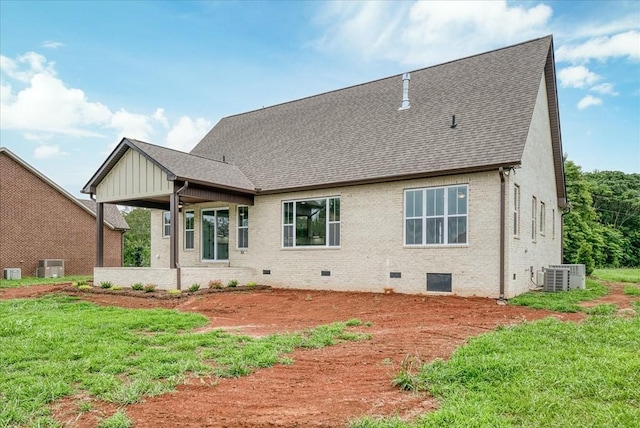 back of property featuring cooling unit, brick siding, roof with shingles, and crawl space
