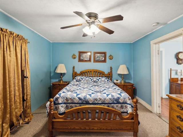 carpeted bedroom with ornamental molding, baseboards, and a ceiling fan
