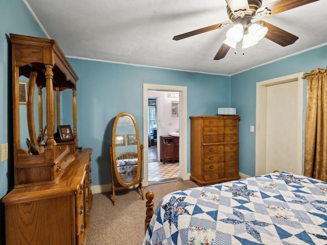 bedroom featuring carpet flooring, ensuite bathroom, and a ceiling fan