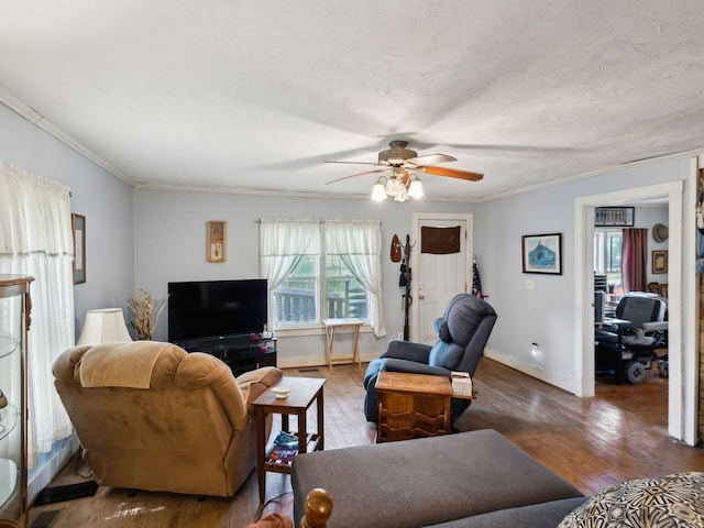 living room featuring ornamental molding, wood finished floors, baseboards, and ceiling fan