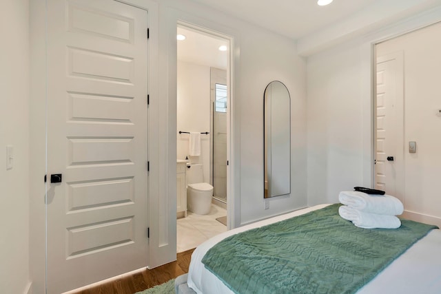bedroom featuring connected bathroom, wood finished floors, and recessed lighting
